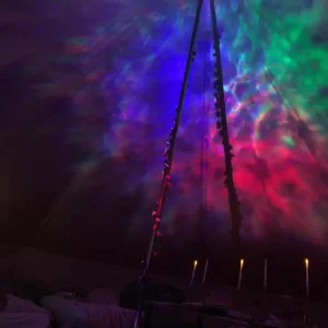 A Texas party rental tent with colorful lights in the middle of it.