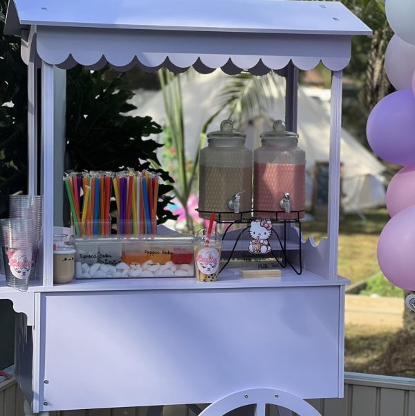 An elegant white snack cart adorned with colorful balloons.