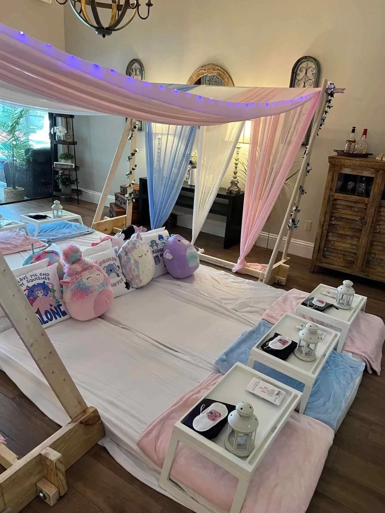 A pink and blue canopy bed with teddy bears on it, available for party rental in Texas.
