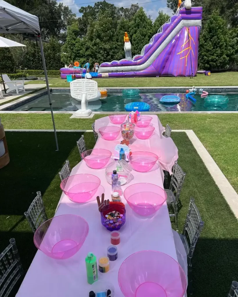 A table set up for a pink party with a water slide at a Texas party rental.