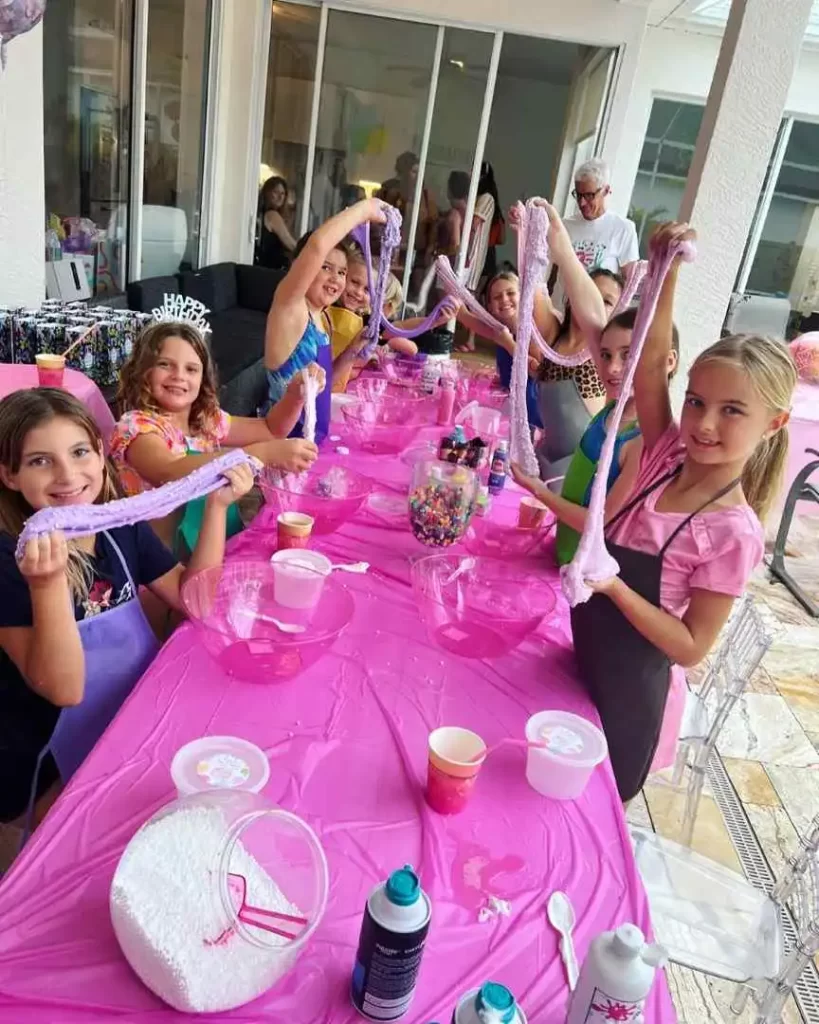 A group of girls at a table with pink tablecloths, set up by a Texas party rental company.