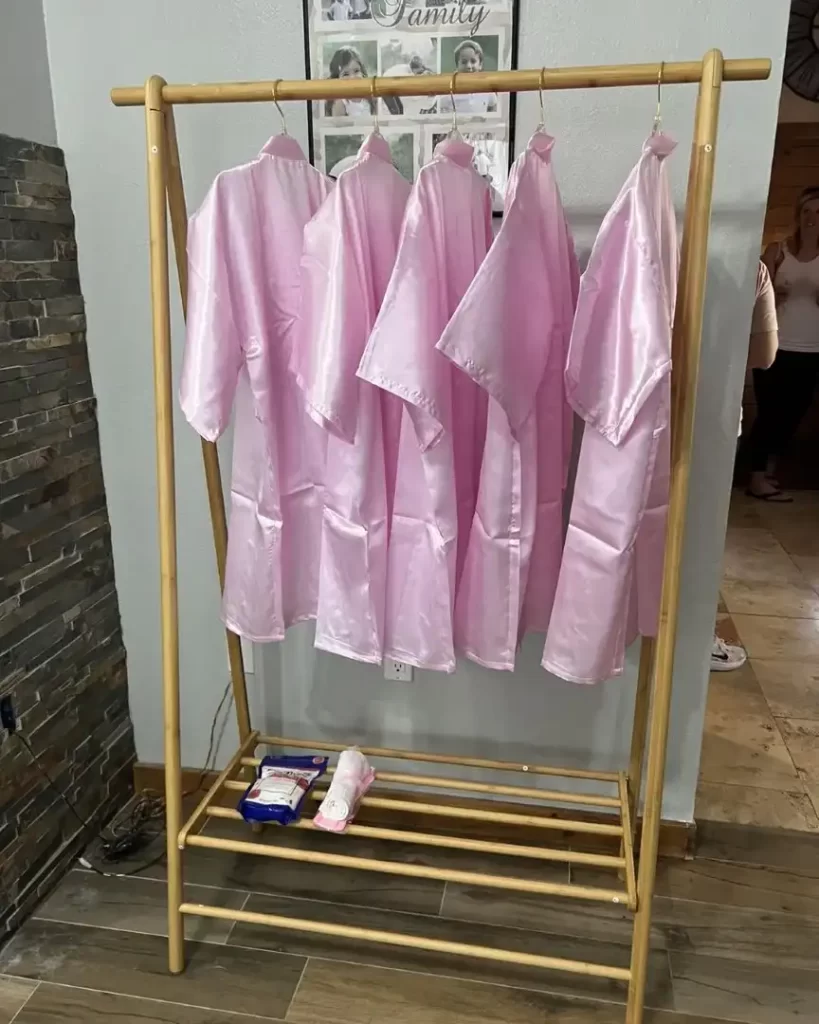 Pink robes hanging on a wooden rack at a Texas party rental.