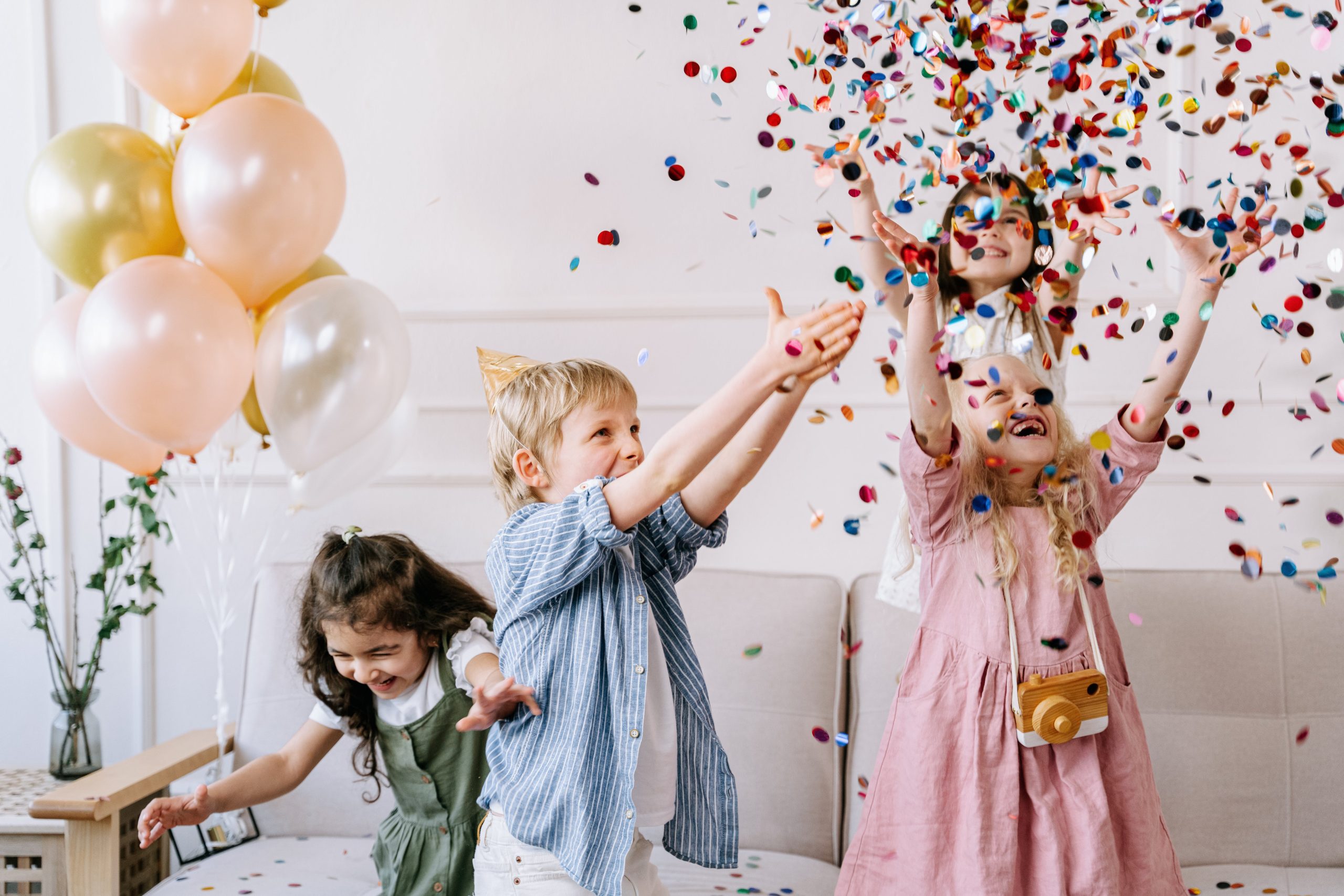 Children playing with confetti at a birthday party in Texas.