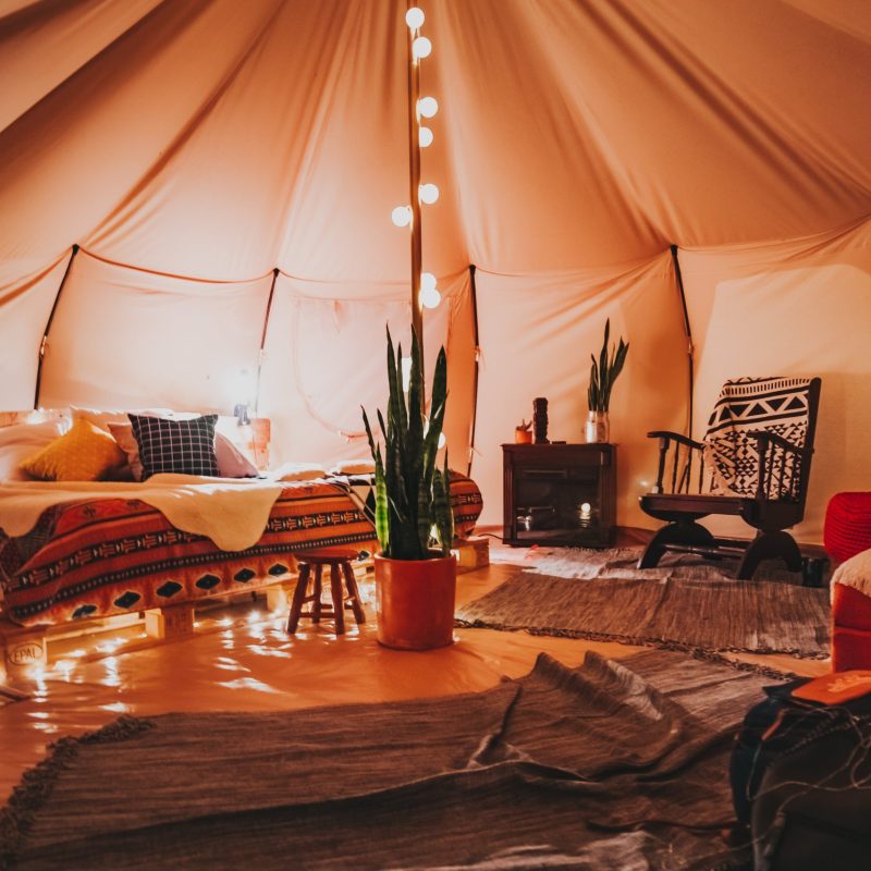 A room in a tent with lights and a bed, perfect for a Texas party rental.